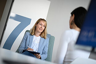 Zwei Frauen sitzen an einem Tisch und reden